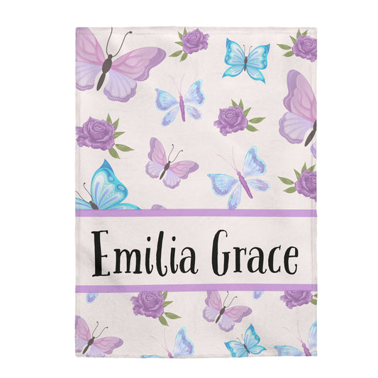 This butterfly blanket has purple and light blue butterflies with purple roses surrounding the blanket. The personalized child's name is in the middle with a purple border separating the name from the butterflies and roses.